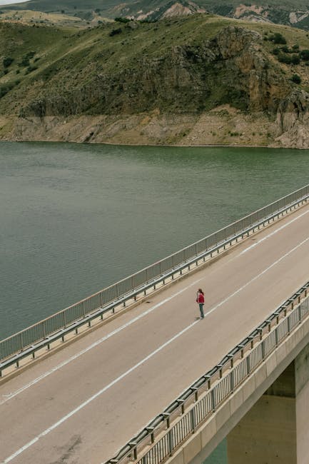 Person standing on bridge over calm water representing wellness journey